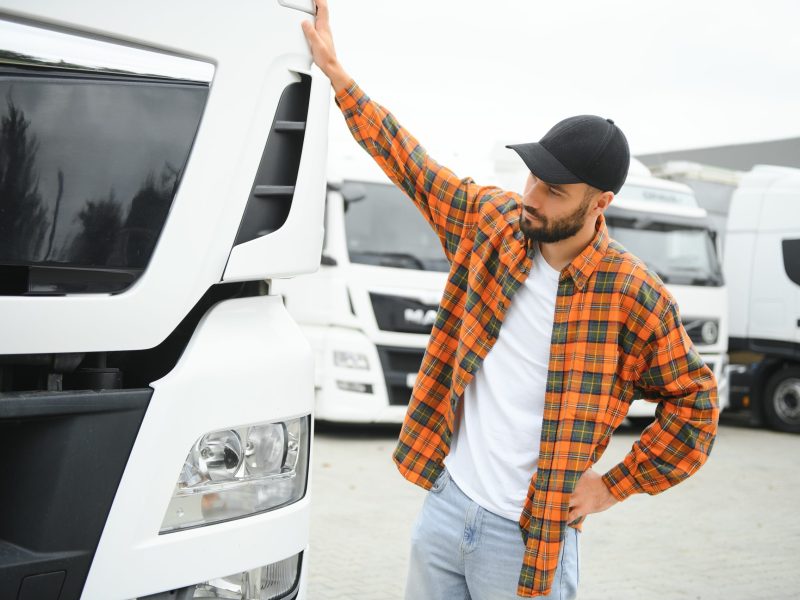 Men driver near lorry truck. Man owner truck driver near truck. Man trucker trucking owner.
